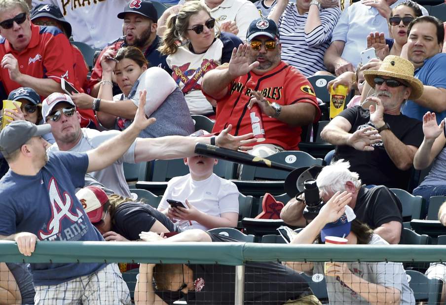 Baseball fan blocks bat from hitting kid